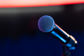 Detail of illuminated microphone in front of neutral background