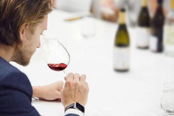 Close up portrait of wine expert tasting red wine based smelling.