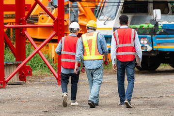 Foreman and worker on construction crane inspection is made to transport the crane from storage to be assembled on the building construction site