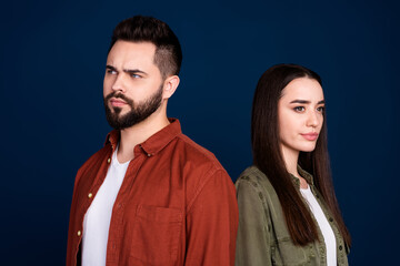 Photo of minded uncertain unsure people couple wife husband wear stylish clothes empty space isolated on dark blue color background