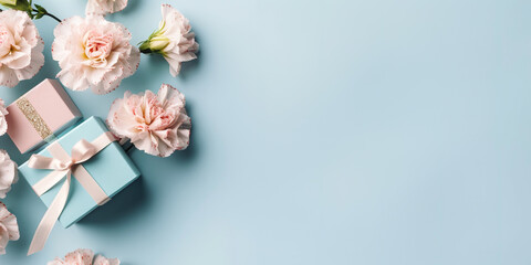 Flat layout of gift boxes and flowers over light blue background