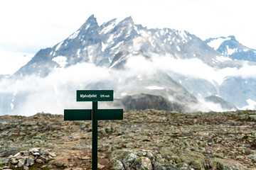 Sign of reaching Mjolvafjellet mountain with viewpoint over Andalsnes. with mountains and snow and clouds in the background