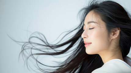 風になびく黒髪ロングヘア：美容とヘアケアイメージの女性の横顔ポートレート写真