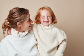 Happy mother and child portrait in beige background representing love and family connection for life moments captured for commercial use