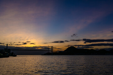 夜明けの関門海峡のカラフルな空に染まる空と波間20240707-3
