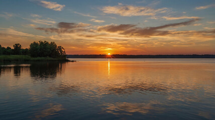Obraz premium Serene Sunset Over a Tranquil Body of Water
