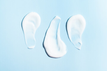 Swatch, smear, creamy texture on blue background. Top view image.