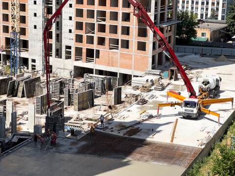 Aerial view of a construction site with heavy machinery for material lifting.
