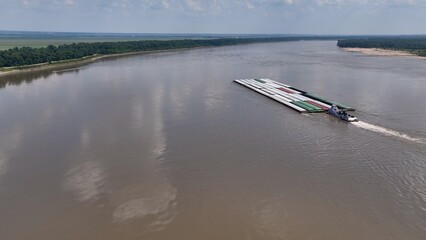 Shipping and commerce on the Mississippi River with boats  transporting  barges with products to various cities 