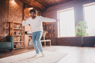 Photo of attractive funny guy wear white sweatshirt earphones dancing enjoying weekend indoors room home house