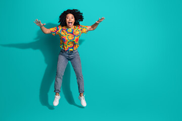 Full length photo of adorable lovely girl wear print t-shirt jumping falling empty space isolated turquoise color background