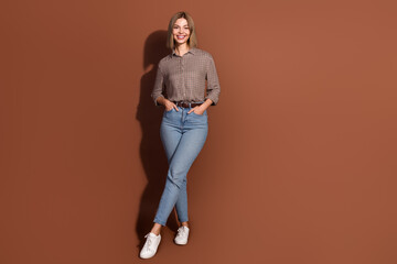 Photo of lovely cute cheerful woman wear checkered stylish clothes isolated on brown color background