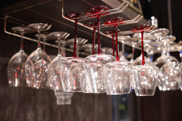 A row of wine glasses hanging from a rack