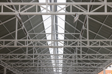 The roof of a building is made of metal and has a white color