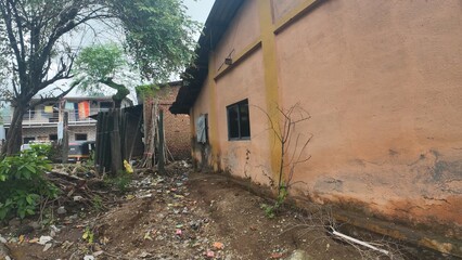 A rural village in Maharashtra under a cloudy sky, showcasing traditional homes and a serene...