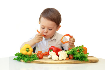 Caucasian boy eats raw vegetables, eating habits and healthy food, isolate on white background