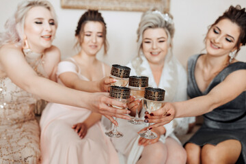 A group of women are celebrating a special occasion, and they are all holding up glasses of champagne