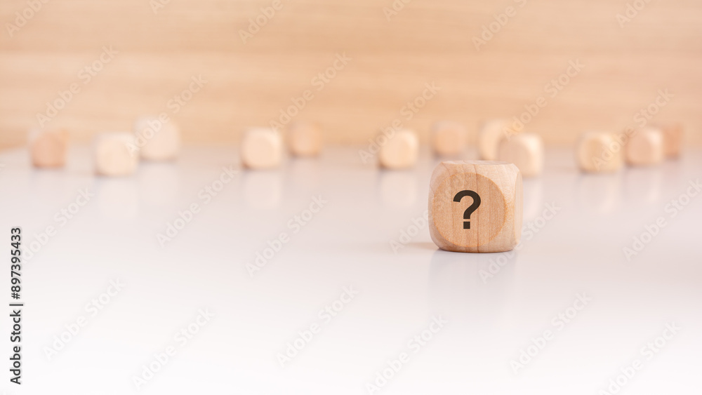 Aufkleber a wooden block with a question mark written on it. many wooden cubes out of focus in the background