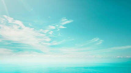 Obraz premium Beautiful seascape with aqua blue water meeting a bright blue sky with white clouds, perfect for travel and nature themes