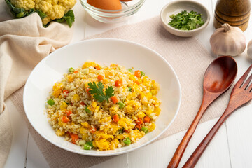 Cauliflower fried rice,Stir fried cauliflower rice with eggs ,carrot ,bean and corn in white plate.healthy eating and low calories food.low carb dish.