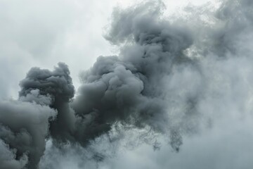 Obraz premium Dark grey smoke billowing from a fire against a cloudy sky
