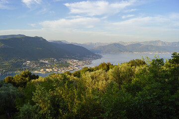 The beauty of the Bay of Kotor: mountains, sea, olive groves, forests and cozy seaside villages. Summer landscape from a viewpoint in the village of Zabrdje on the Lustica Peninsula, Montenegro