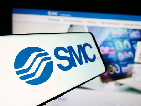 Stuttgart, Germany - 07-25-2024: Cellphone with logo of Japanese machinery company SMC Corporation in front of business website. Focus on center-left of phone display.