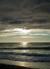 the sun over the stormy sea, sea waves in the rays of the sun, a sun path on the surface of the sea