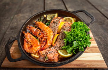 Healthy baked salmon steaks with greens and asparagus in a black cast iron skillet. A delicious low-carb breakfast.