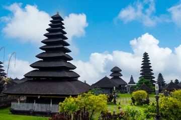 Multi-tiered shrines of Besakih Temple standing tall against a bright blue sky.
