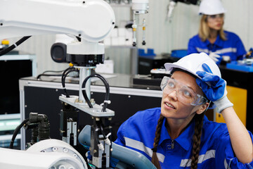 female automation machine engineer student study and operating control robot arm machine in university or factory workshop. ai, automation and robotics technology are trend for future manufacturing