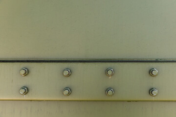 Military green wall with bolts, background photo texture. Steel details