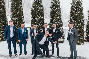A group of men in suits are posing for a picture in the snow. They are all smiling and seem to be...