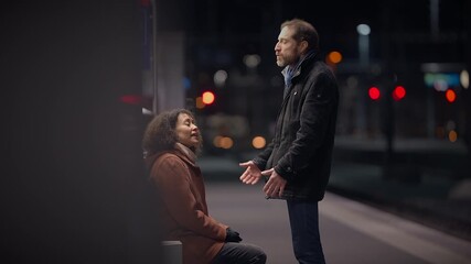 At night, a highstakes disagreement happens in a dramatic train station setting