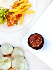Traditional brazilian meal known as prato feito, brazilian snack known as bread of chesse and brazilian truflle known as brigadeiro.