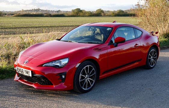 Essex, UK - November 4, 2020: A red Toyota GT 86 car parked on a rural road. 