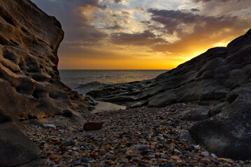 Russia. Dagestan. Dawn on the seashell-strewn rocky shore of the Caspian Sea near the city embankment of Makhachkala.