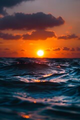 Fototapeta premium A sunset over the ocean with waves.