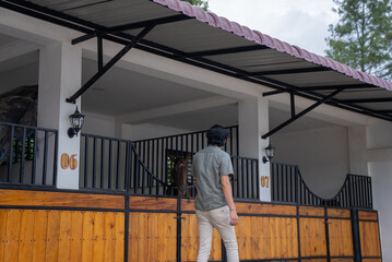 Fototapeta premium A man walks in a horse barn. A man looks at his horse stable