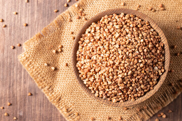 Buckwheat groats on wooden background. Healthy cereal concept.  