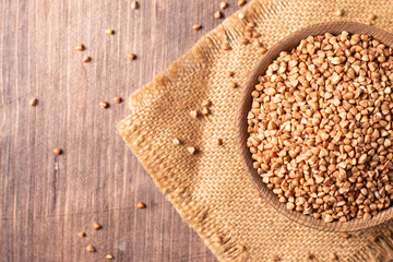 Buckwheat groats on wooden background. Healthy cereal concept.  