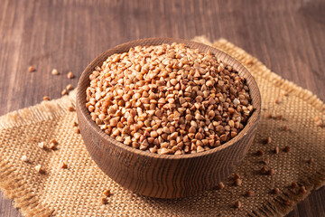 Buckwheat groats on wooden background. Healthy cereal concept.  