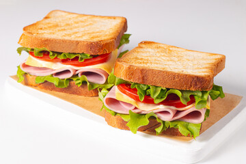 Club sandwich with ham, cheese, tomato and lettuce. 
