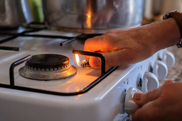 hand adjusting gas burning from a kitchen gas stove