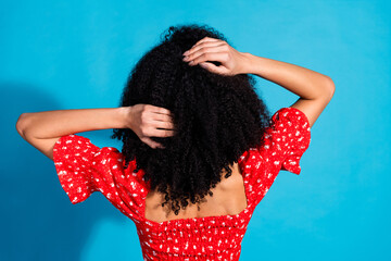 Rear portrait of gorgeous young woman touch hair wear top isolated on blue color background