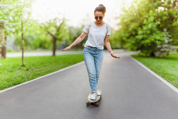 Woman Skateboarding In A Park Sunny Day