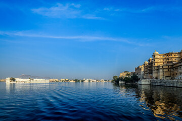 Romantic India luxury tourism background - Udaipur City Palace and Lake Palace on Lake Pichola. Udaipur, Rajasthan, India