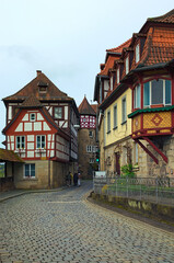 Fototapeta premium Scenic landscape view of street with ancient houses under red tile in the old town of Kronach. Typical architecture in Bavaria, region Upper Franconia, Germany