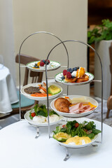 Elegant multi-tier brunch setup with a variety of dishes. Concept of fine dining, culinary art and delicious dishes. High quality photo