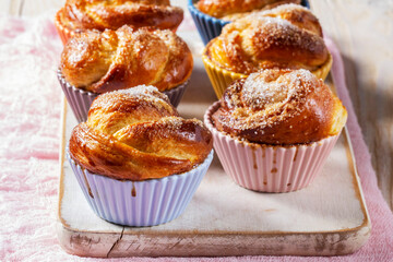 Rose-shaped yeast dough buns sprinkled with sugar in ceramic molds.